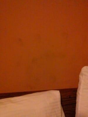 Stains on the wall above the headboard