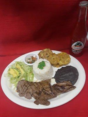 carne asada acompañada de tostones ensalada y frijol , arroz el mejor zason