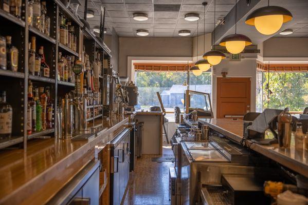 Industrial shelving and repurposed bowling alley lanes bar tops complement other repurposed industry elements, like machine legs and art.