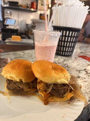 Two double cheeseburgers with onions and a strawberry shake