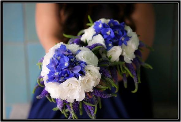 Bridesmaid bouquets of blue and white flowers.  White lisisanthus, blue belladonna and veronica.