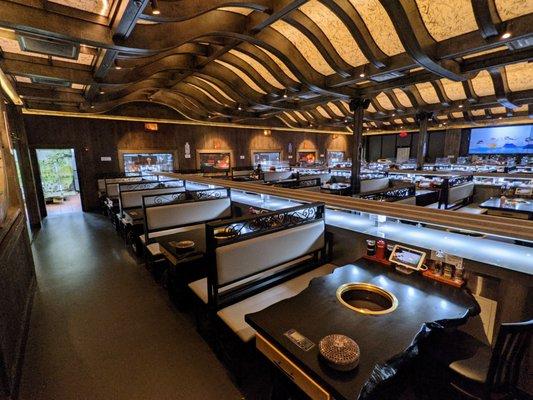 Inside. Dining room. There are three conveyor belts, each surrounded on either side by five booths. Some booths seat four, others six.