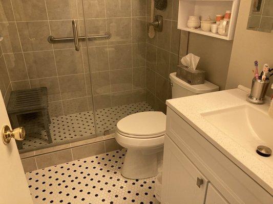 Complete bathroom renovation with tub removal, newly-created shower, new vanity,Koehler toilet, all cabinetry, and new retro tile floor.