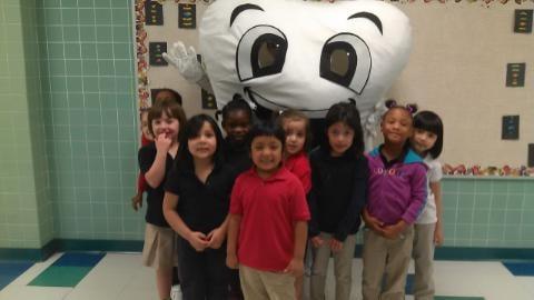 Smiley educating Pre K students on how to keep healthy teeth.