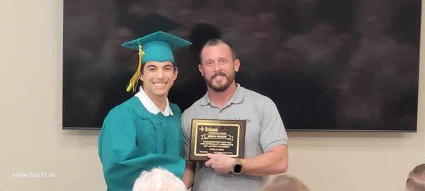 Receiving my plaque for graduating the program being given to me by Parker Haslam the best man behind my father.