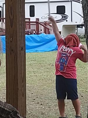 Kids are trying to break the pinata at a birthday celebration at the pavilion.