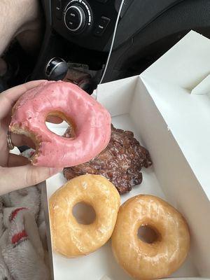 Strawberry frosted donut, glazed donuts, and an apple fritter