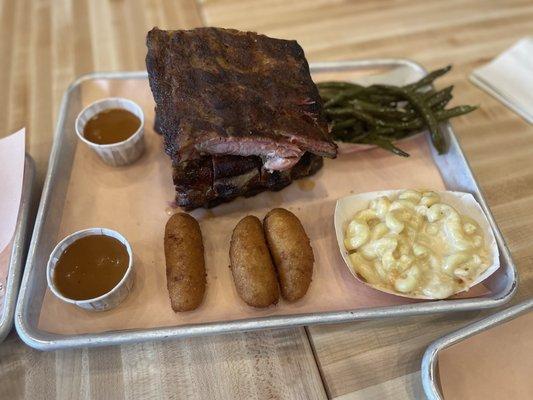 Full rack of Full-Rack St. Louis Cut Pork Ribs Tray with macaroni and green beans.