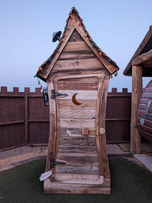 Cute outhouse with a golden toilet