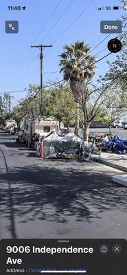 Right in front of the new location, a homeless camp.