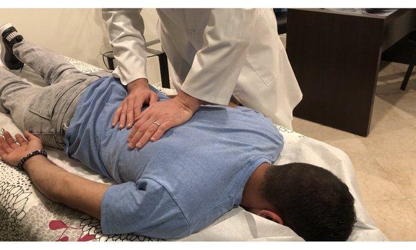 checking patients spine for mis-alignments.