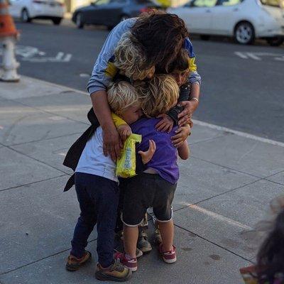 Kids hug their daycare provider