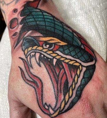 Eddie Peralta did this traditional snake head hand tattoo