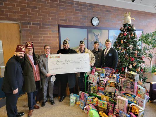 Donating toys and a giant check to Shriners Children's Hospital