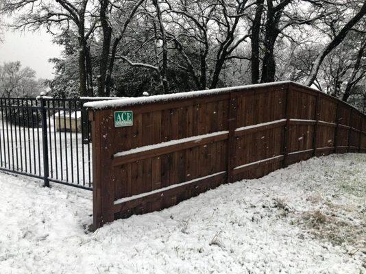 Snowy picture of a 6 foot wood privacy fence with top cap and trim