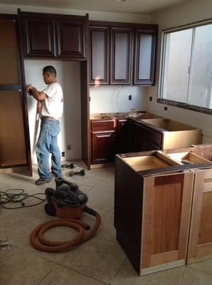 Ben hard at work hanging cabinets for a kitchen remodeling project.