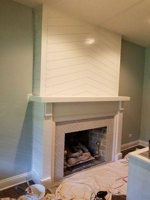 fireplace mantel with shiplap panels above