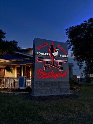 Brick & Bones Backyard sign at night. Eye grabber off of Main Road!