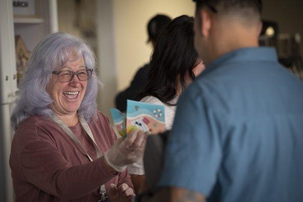 A volunteer hands out a donut at our hospitality area before one of our Sunday services.