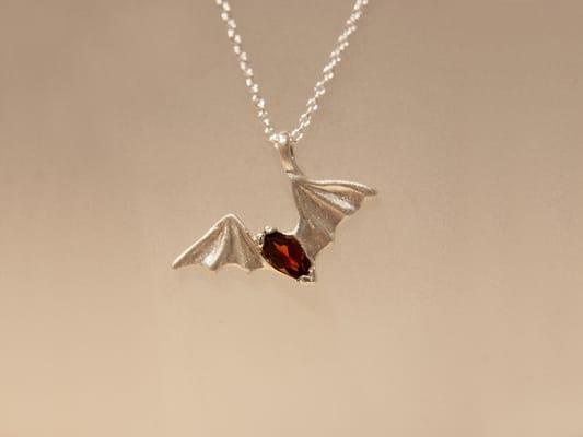 Freetail Bat Pendant pictured with a Garnet gemstone. Designer: Franzetti Design