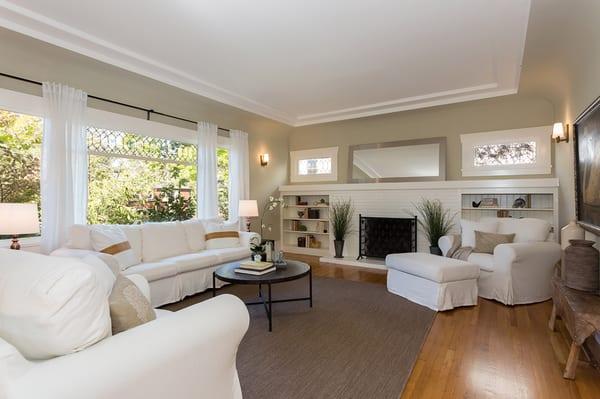 Spacious formal living room with coved ceilings and a wood-burning fire place.