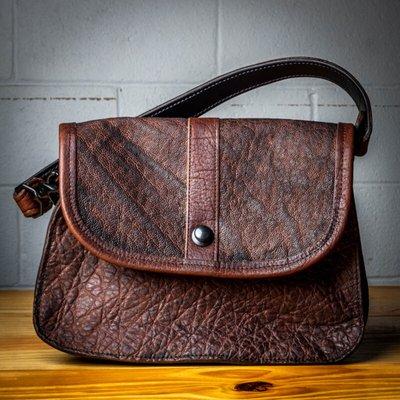 A custom "Serenity" bag made out of brown elephant leather with dark brown bison accents and black hardware.