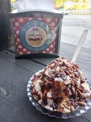 Sundae with hot fudge and hot caramel topped with whipped cream and pecans