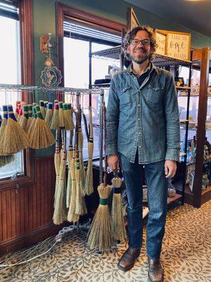 Broommaker Dustin Cecil and some of his handmade brooms.