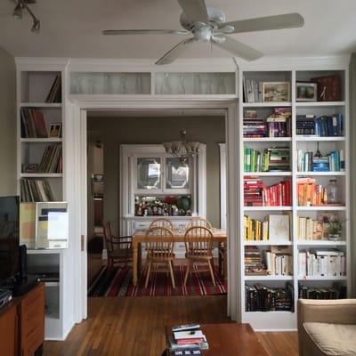 A full wall of shelves that accommodates for original built-in pocket doors, cable wiring, and a big old record player!