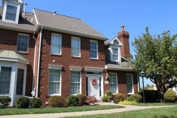 A brick townhouse with a recently replaced roof.