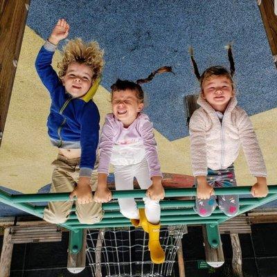 Kids hang upside down on a playground