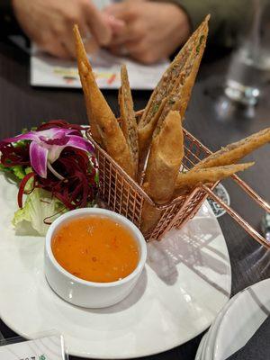 Pork eggrolls with sweet and sour sauce.