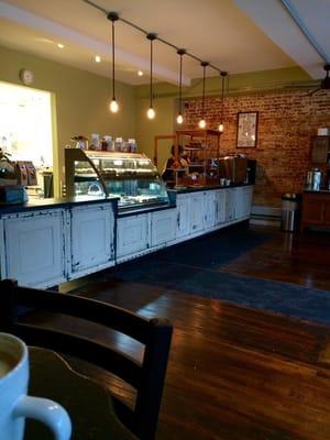 A beautiful display of pastries with a great kitchen in back.