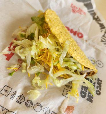 Snack taco with freshly grated cheese and shredded iceberg lettuce