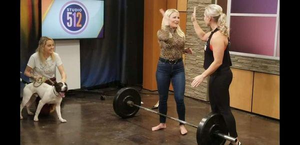 Krista coaching a deadlift on the news while promoting Pull for Paws.