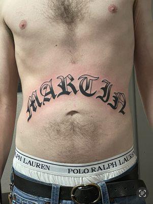 Last name stomach bomber tattoo done by Tyler