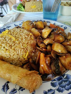 Mushrooms, shrimp, and scallops with fried rice and egg roll.