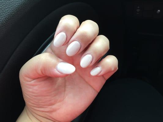 Acrylic almond-shaped nails with nude pink gel polish.