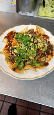 Lunch Chilaquiles with Birria. Topped with cheese cilantro and onion