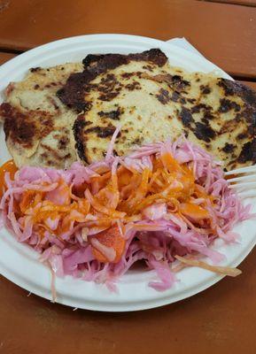 Two pupusas (frijoles con queso and loroco con queso) served with curtido