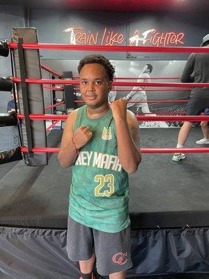 Manuel standing in front of boxing ring at brick city.