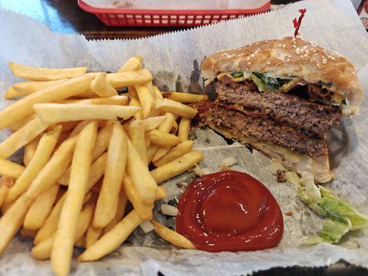 Double patty bacon cheeseburger with fries.