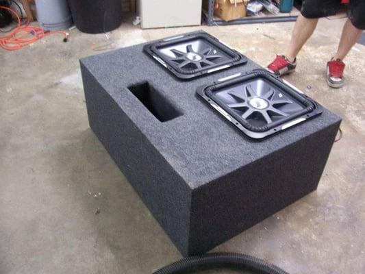 A Pro Car Audio technician finishing up a basic ported custom enclosure for two Kicker Solobaric L7 sub-woofers