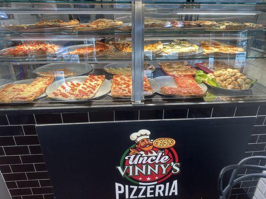 The wide selection of pizzas by the slice.