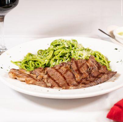 Tallarin verde con Bisteck. Spaghetti mixed with peruvian pesto sauce and a  Rib-Eye steak on Top