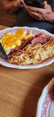 Scrambled eggs with cheese, bacon, hash browns, and sourdough bread...  perfectly cooked and very filling