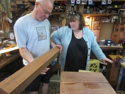 Harrison helping Sally Van Meter choose wood for her custom guitar.