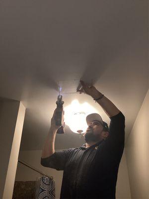 Plumber Javier cutting section of ceiling for leak inspection