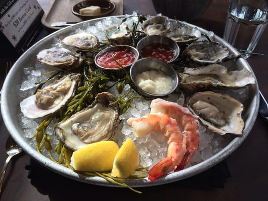 Raw platter platter with oysters, shrimp, lemon, cocktail sauce, mignonette, horseradish