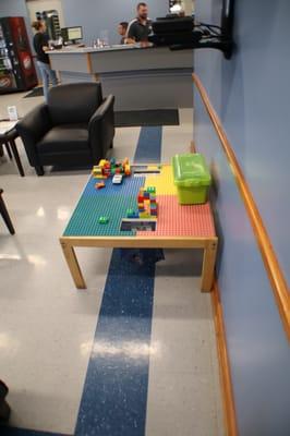 A lego table is in the waiting room for kids to enjoy.